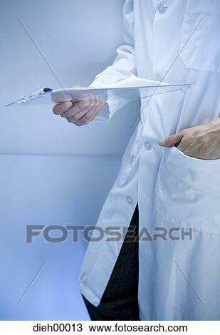 Lab worker in lab coat holding chart View Large Photo Image Stock Image - Lab worker in lab coat holding chart. Fotosearch