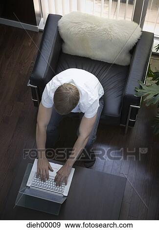 Looking down on man with laptop View Large Photo Image Stock Photo - Looking down on man with laptop. Fotosearch