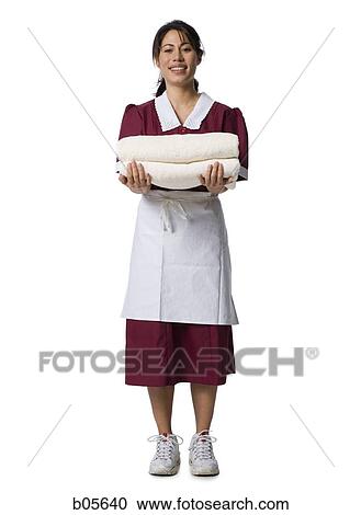 Maid standing with towels smiling View Large Photo Image Stock Image - Maid standing with towels smiling. Fotosearch