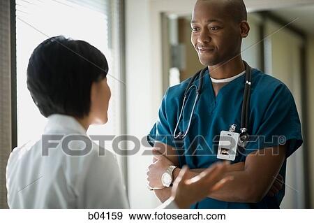 Male and female doctors talking View Large Photo Image Stock Photo - Male and female doctors talking. Fotosearch