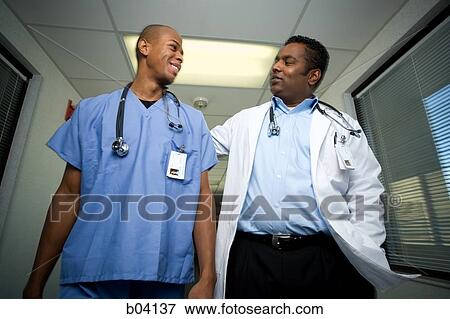 Male doctor and hospital worker talking View Large Photo Image Stock Photo - Male doctor and hospital worker talking. Fotosearch