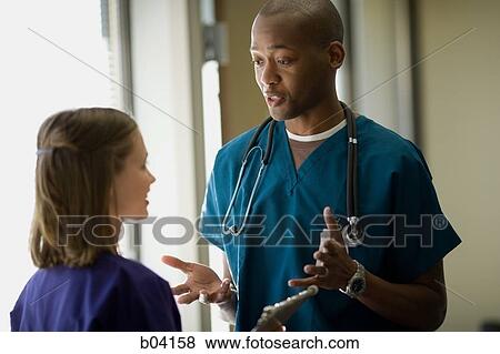 Male doctor explaining to nurse View Large Photo Image Stock Photo - Male doctor explaining to nurse. Fotosearch