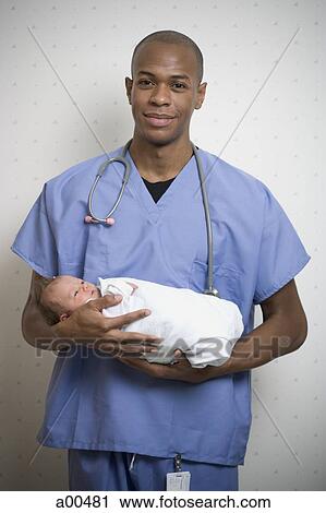Male Doctor holding newborn baby View Large Photo Image Stock Image - Male Doctor holding newborn baby. Fotosearch