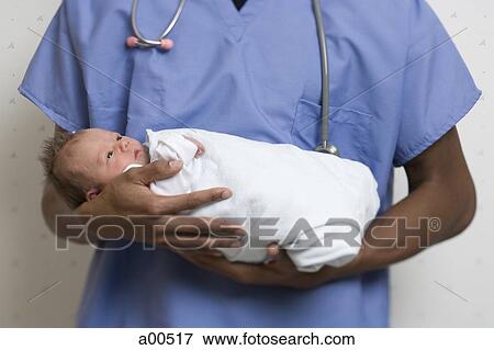 Male Doctor holding newborn baby View Large Photo Image Stock Photo - Male Doctor holding newborn baby. Fotosearch