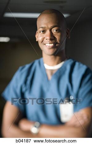 Male doctor with crossed arms smiling View Large Photo Image Stock Photo - Male doctor with crossed arms smiling. Fotosearch