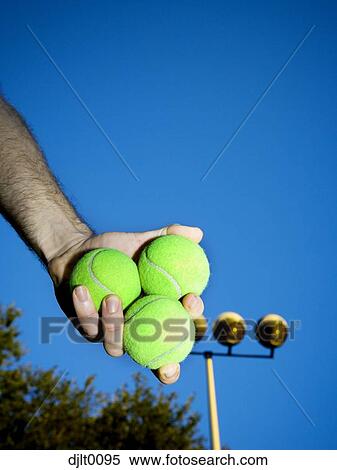 Stock Photography - Male hand holding three tennis balls. Fotosearch