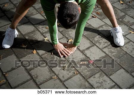 Stock Image - Male jogger stretching. Fotosearch