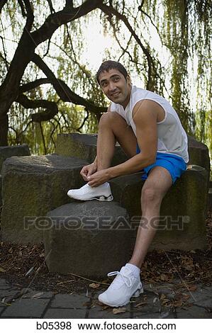 Male jogger tying shoelaces in forest View Large Photo Image Stock Photo - Male jogger tying shoelaces in forest. Fotosearch