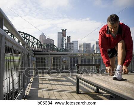 Male jogger tying shoelaces View Large Photo Image Picture - Male jogger tying shoelaces. Fotosearch