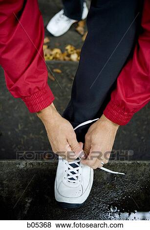 Male jogger tying shoelaces View Large Photo Image Stock Photo - Male jogger tying shoelaces. Fotosearch