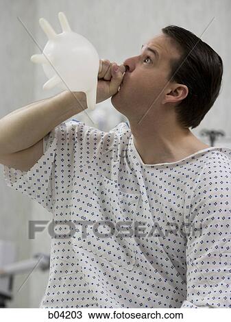 Male patient in hospital gown blowing up rubber glove View Large Photo Image Stock Image - Male patient in hospital gown blowing up rubber glove. Fotosearch