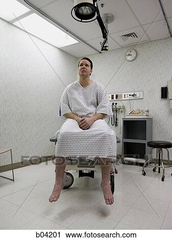 Stock Image - Male patient waiting on examining table. Fotosearch
