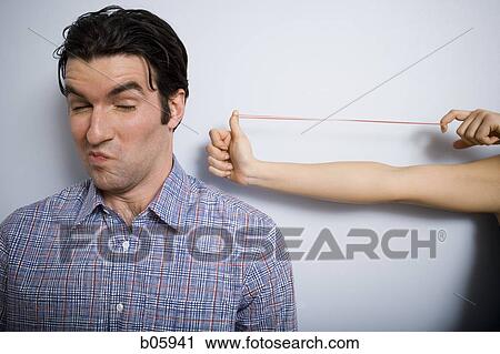 Man almost getting hit with rubber band View Large Photo Image Stock Image - Man almost getting hit with rubber band. Fotosearch