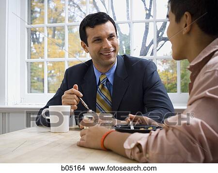 Man and boy at breakfast table smiling View Large Photo Image Picture - Man and boy at breakfast table smiling. Fotosearch