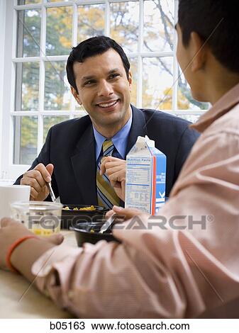 Man and boy at breakfast table smiling View Large Photo Image Stock Image - Man and boy at breakfast table smiling. Fotosearch