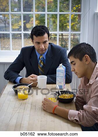Man and boy at breakfast table displeased View Large Photo Image Stock Image - Man and boy at breakfast table displeased. Fotosearch