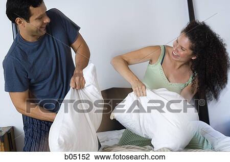 Man and woman having pillow fight on bed laughing View Large Photo Image Stock Image - Man and woman having pillow fight on bed laughing. Fotosearch