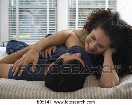 Man and woman on bed snuggling View Large Photo Image Stock Photo - Man and woman on bed snuggling. Fotosearch
