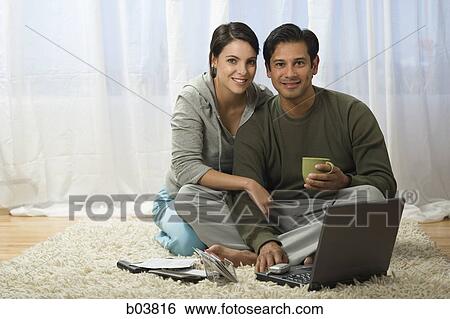 Man and woman on carpet with laptop View Large Photo Image Stock Photograph - Man and woman on carpet with laptop. Fotosearch