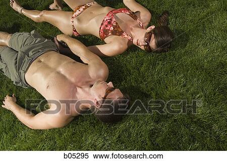 Man and woman sunbathing on grass View Large Photo Image Stock Photography - Man and woman sunbathing on grass. Fotosearch