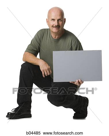 Man crouching with blank sign View Large Photo Image Stock Photography - Man crouching with blank sign. Fotosearch