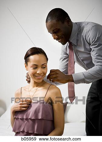 Man doing up a woman's necklace clasp View Large Photo Image Stock Photo - Man doing up a woman's necklace clasp. Fotosearch