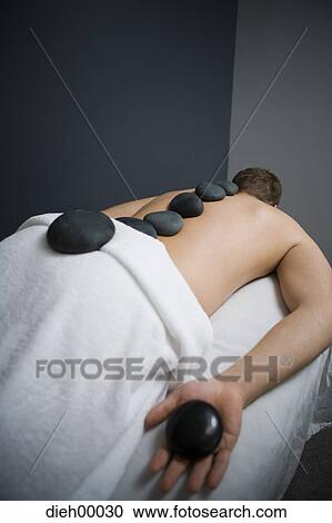 Man having a back massage with rocks View Large Photo Image Stock Image - Man having a back massage with rocks. Fotosearch