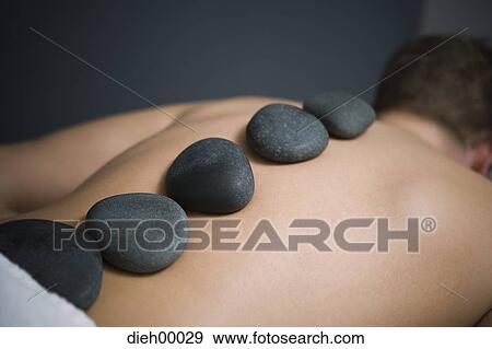 Man having a back massage with rocks View Large Photo Image Stock Photo - Man having a back massage with rocks. Fotosearch