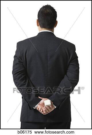 Man holding an engagement ring behind his back View Large Photo Image Stock Photography - Man holding an engagement ring behind his back. Fotosearch