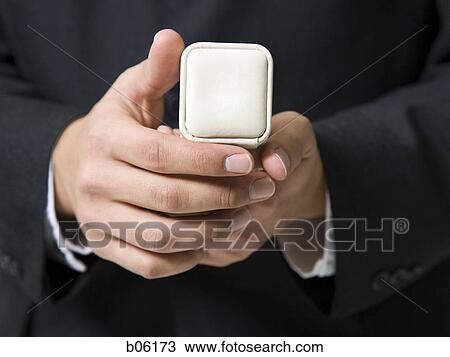 Man holding an engagement ring View Large Photo Image Stock Image - Man holding an engagement ring. Fotosearch