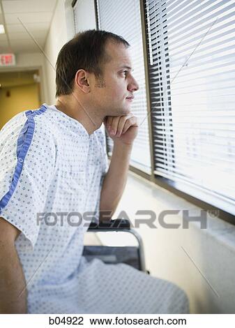 Man in hospital gown sitting in wheelchair looking through window View Large Photo Image Stock Image - Man in hospital gown sitting in wheelchair looking through window. Fotosearch