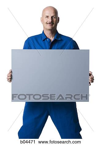 Man in overalls standing with blank sign View Large Photo Image Stock Image - Man in overalls standing with blank sign. Fotosearch