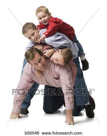 Man kneeling with three boys crawling on him View Large Photo Image Stock Photograph - Man kneeling with three boys crawling on him. Fotosearch