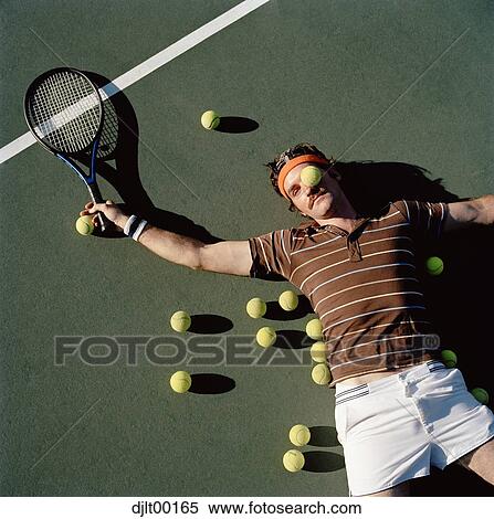 Stock Photography - Man lying down on a tennis court. Fotosearch