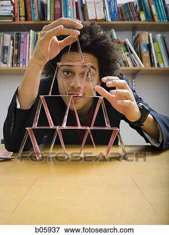 Man making a pyramid out of playing cards View Large Photo Image Stock Photo - Man making a pyramid out of playing cards. Fotosearch