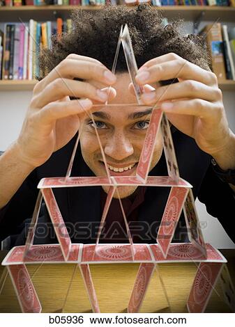 Man making a pyramid out of playing cards View Large Photo Image Stock Photograph - Man making a pyramid out of playing cards. Fotosearch