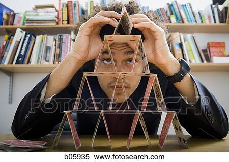 Man making a pyramid out of playing cards View Large Photo Image Stock Photography - Man making a pyramid out of playing cards. Fotosearch