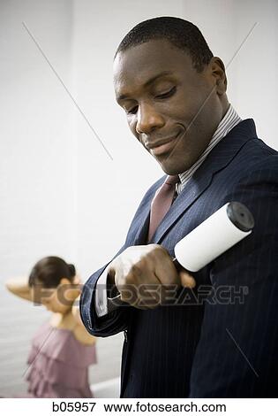 Man rolling lint off his blazer View Large Photo Image Stock Photo - Man rolling lint off his blazer. Fotosearch