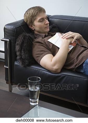 Stock Photo - Man sleeping on leather sofa. Fotosearch