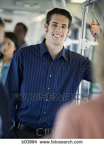 Man standing on city bus or subway View Large Photo Image Picture - Man standing on city bus or subway. Fotosearch