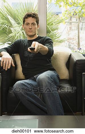 Stock Image - Man with a remote control. Fotosearch