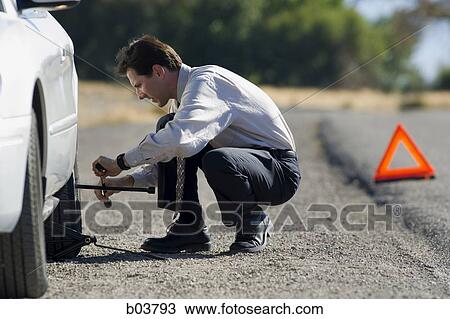 Man with car jack View Large Photo Image Stock Image - Man with car jack. Fotosearch
