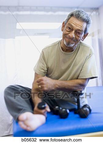 Man with one leg sitting and exercising with weights View Large Photo Image Stock Image - Man with one leg sitting and exercising with weights. Fotosearch