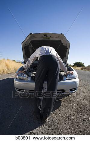 Stock Image - Man with open car engine. Fotosearch