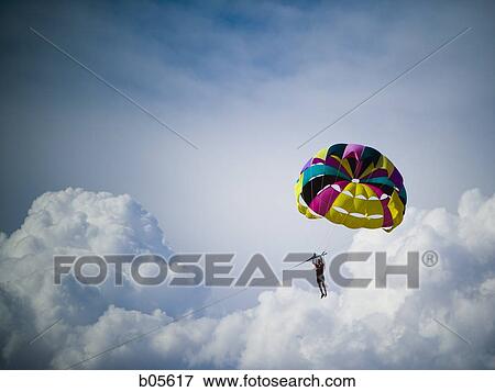 Stock Photo - Man with parachute floating. Fotosearch