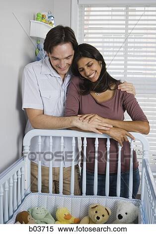 Married couple leaning on baby crib View Large Photo Image Stock Photography - Married couple leaning on baby crib. Fotosearch