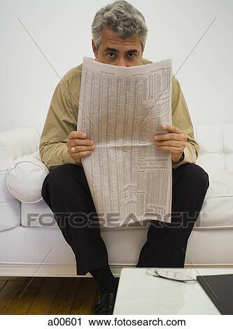 Mature businessman sitting on sofa hiding behind newspaper View Large Photo Image Stock Image - Mature businessman sitting on sofa hiding behind newspaper. Fotosearch