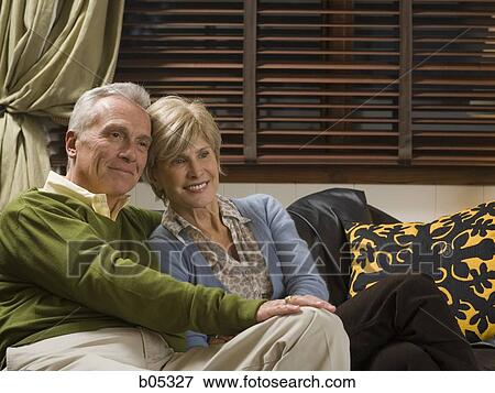 Mature couple cuddling on sofa View Large Photo Image Stock Photo - Mature couple cuddling on sofa. Fotosearch