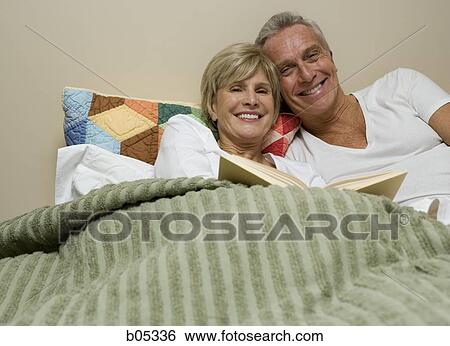Mature couple in bed reading View Large Photo Image Stock Photograph - Mature couple in bed reading. Fotosearch