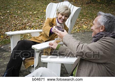Mature couple in wooden chairs toasting View Large Photo Image Stock Image - Mature couple in wooden chairs toasting. Fotosearch